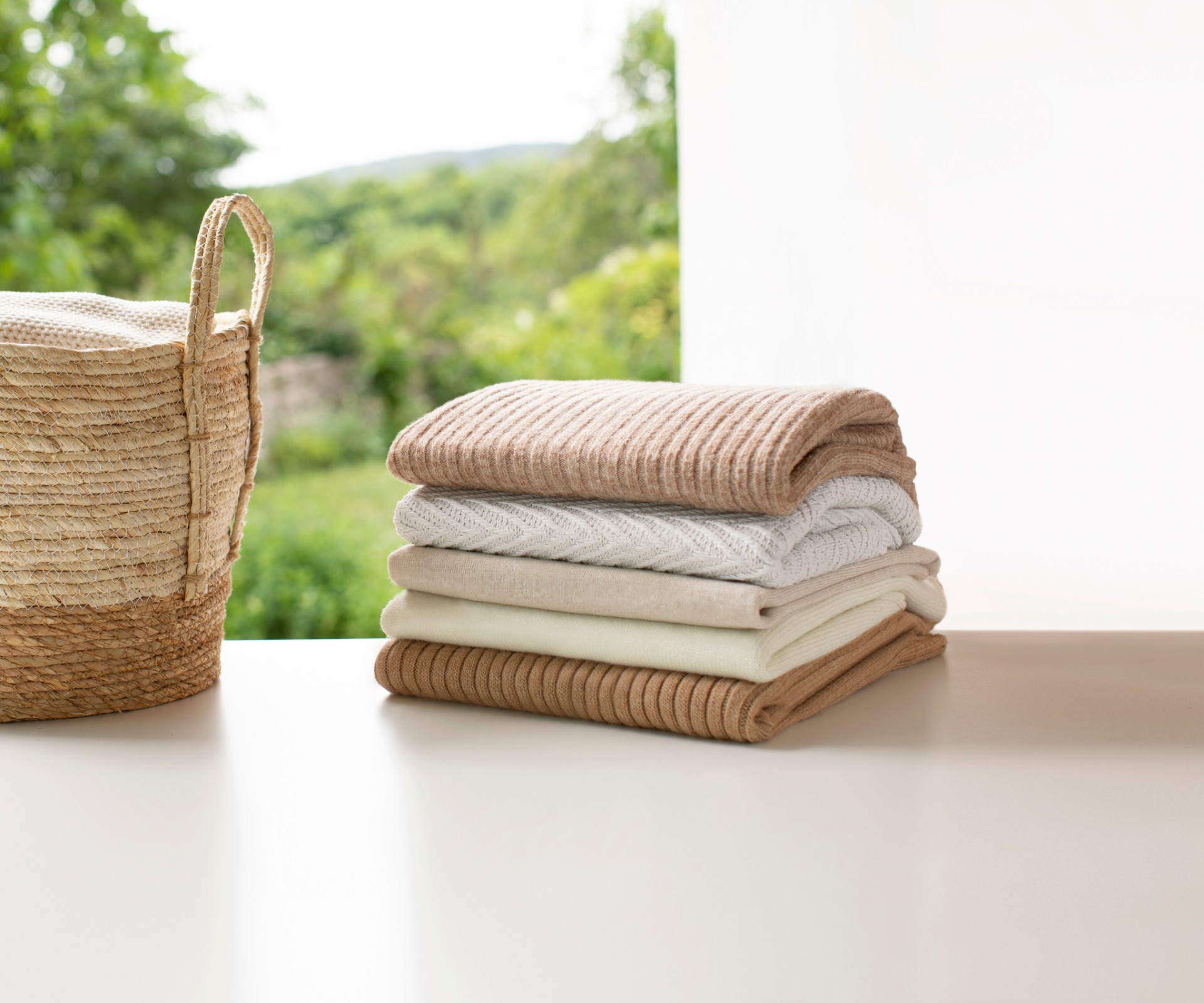 Stacked towels lying next to a basket with laundry